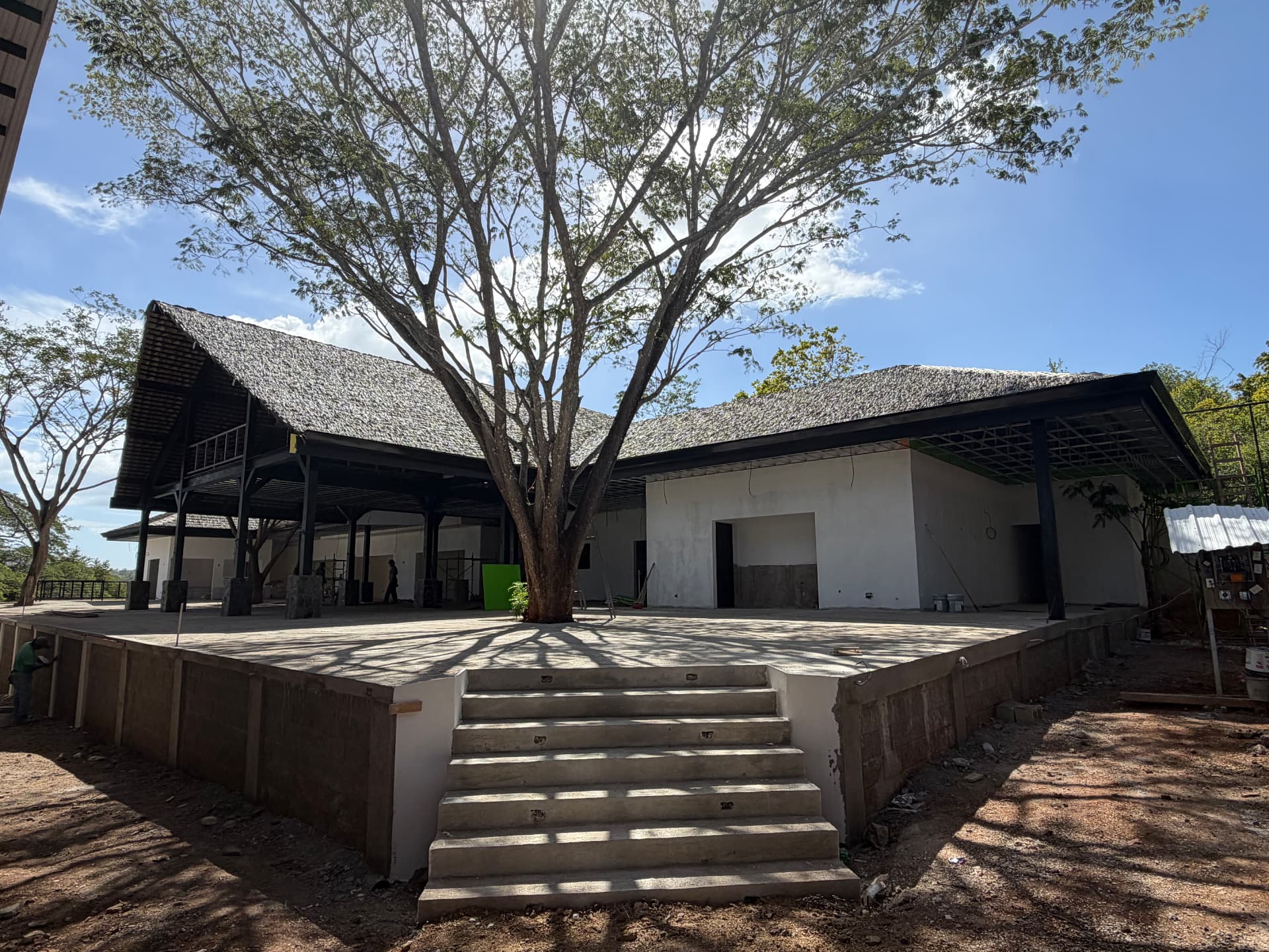 Open-air clubhouse pavilion under a large tree at Finca Escondida