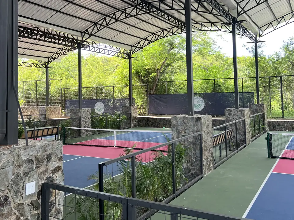Pickleball courts with stone pillars and the club crest