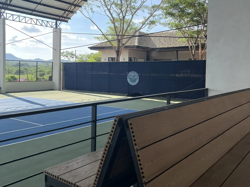 Bench beside a covered tennis court