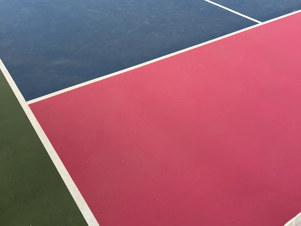 Lines on a pickleball court in the club's blue, pink and green